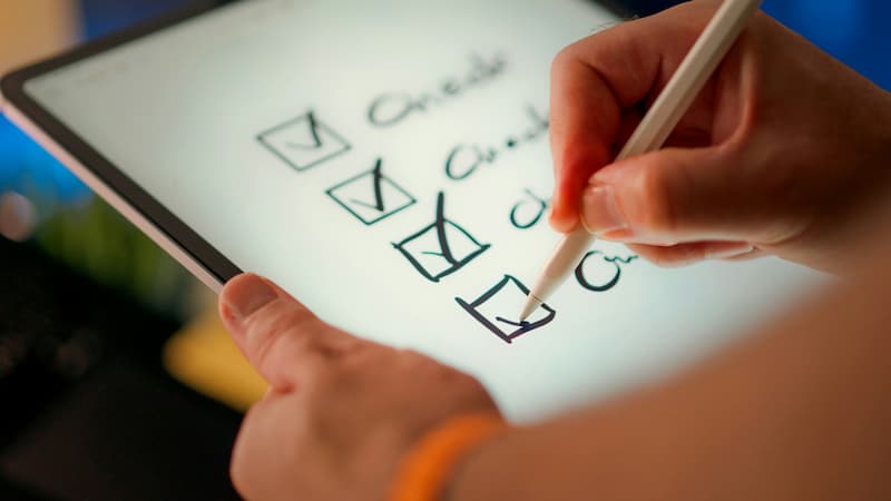 Checking eligibility boxes on a tablet screener